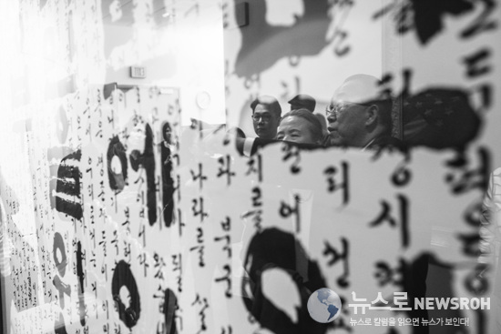 Mr. Ban and his wife, Yoo Soon-taek, seen in a reflection of the Gettysburg Address written in Korean.jpg